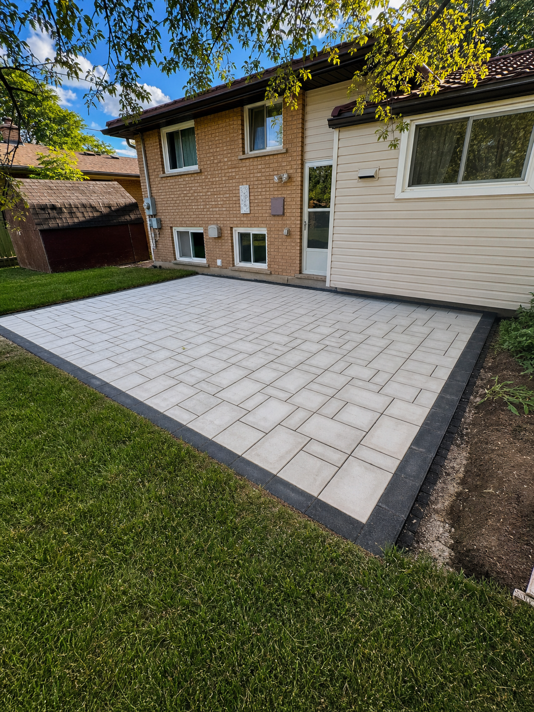 Clean interlocking patio installation with dark border by Brothers Landscaping in London Ontario