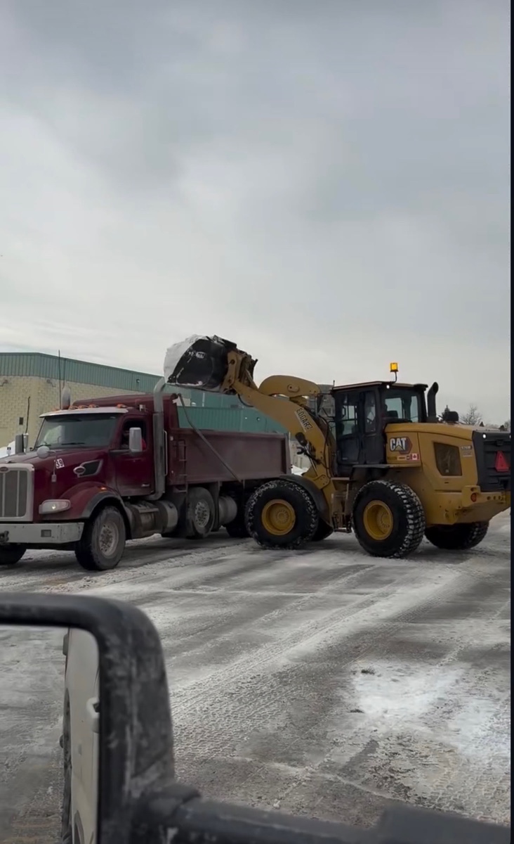 Loader and dump truck working at a commercial property