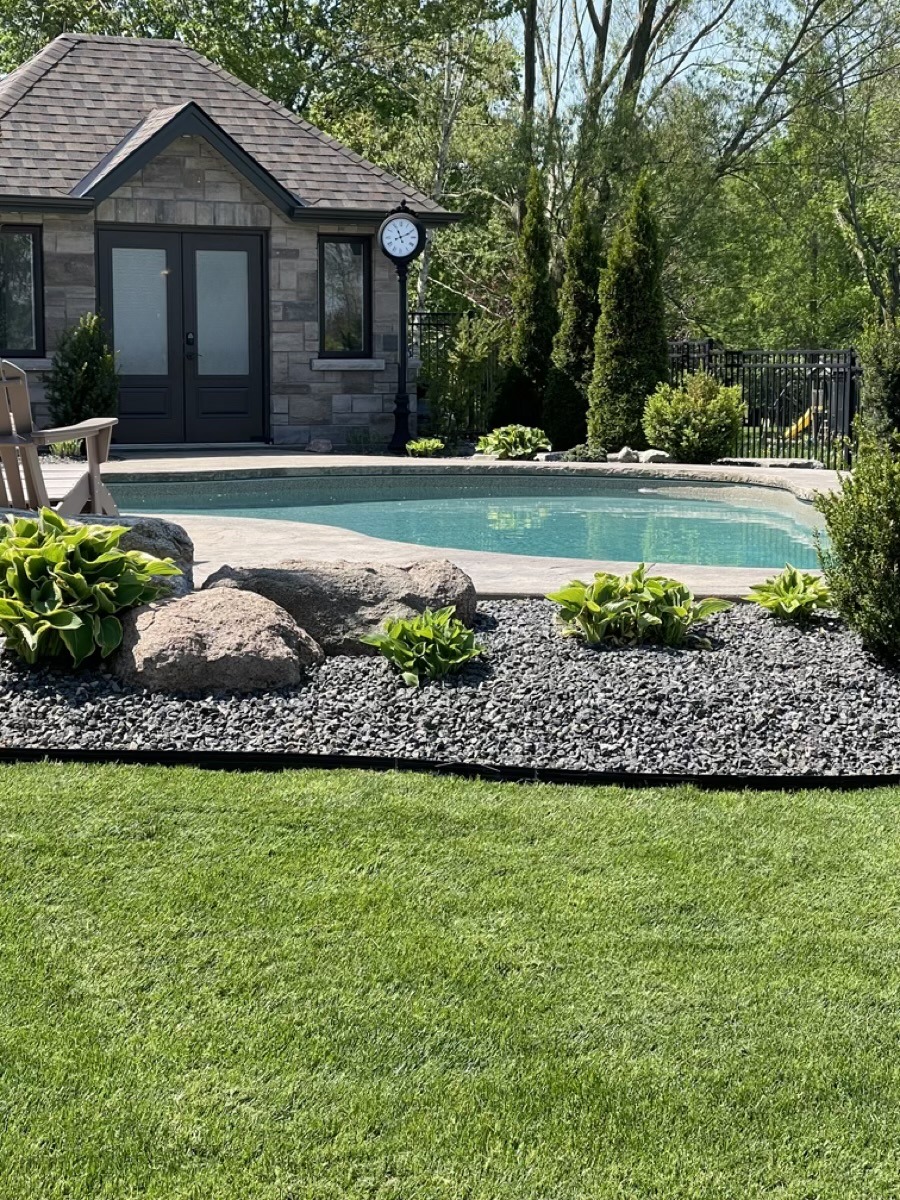 Finished pool garden with lawn, stone, and planting by Brothers Landscaping