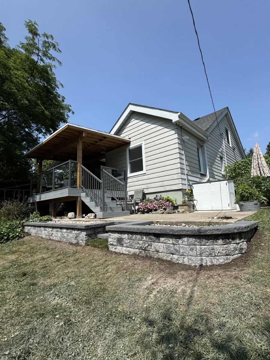 Retaining wall and patio work beside a finished backyard
