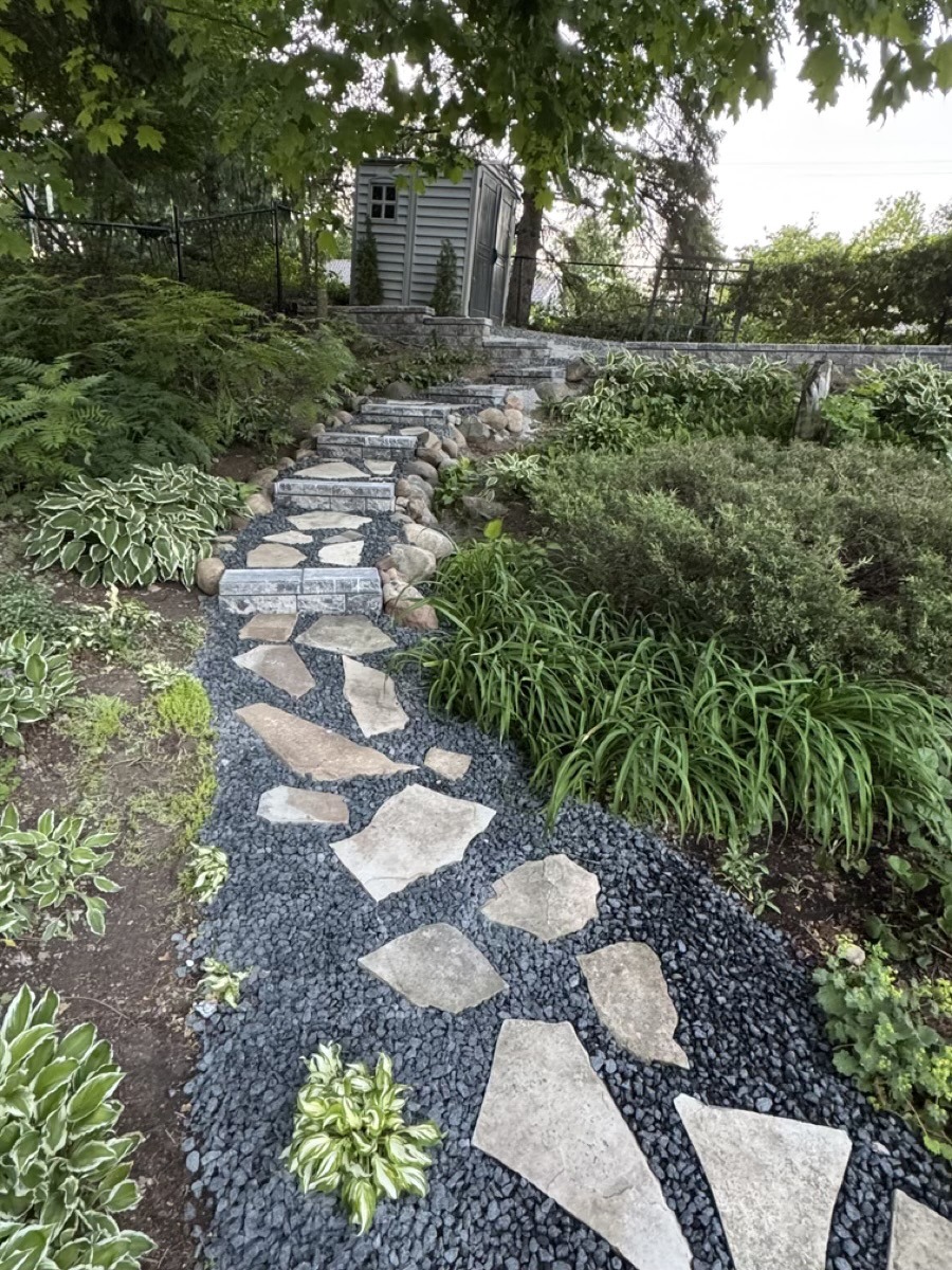Stepping-stone walkway winding through a finished garden by Brothers Landscaping