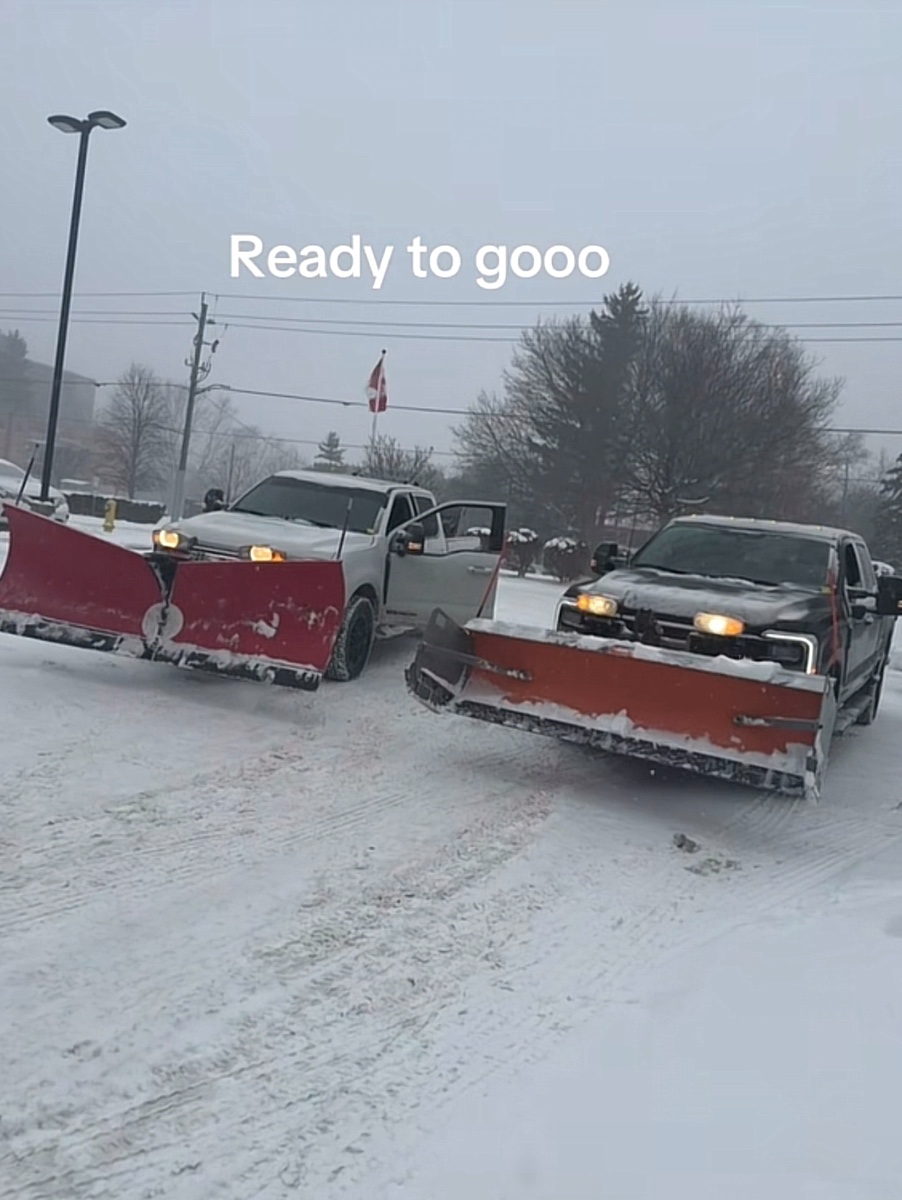 Two plow trucks working in a winter storm